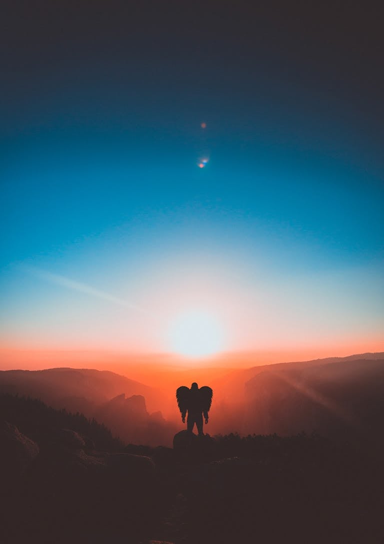 A mesmerizing sunset with silhouette of a person with wings, capturing a serene and ethereal moment.